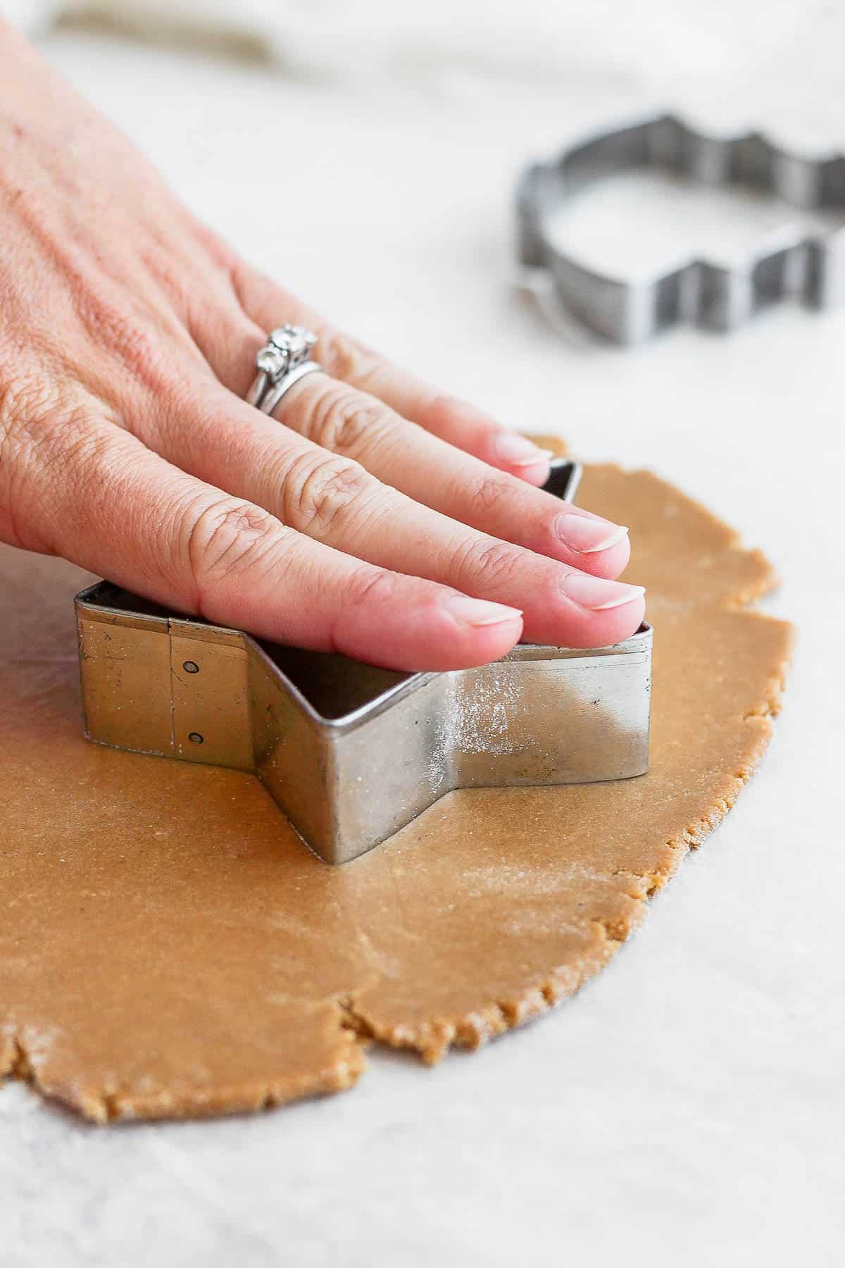 Cutting out a gluten free sugar cookie using a star cut-out.