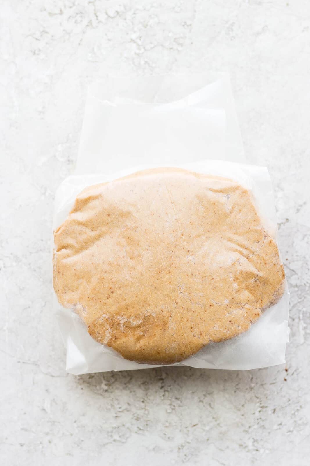 Almond flour sugar cookie dough wrapped in wax paper.