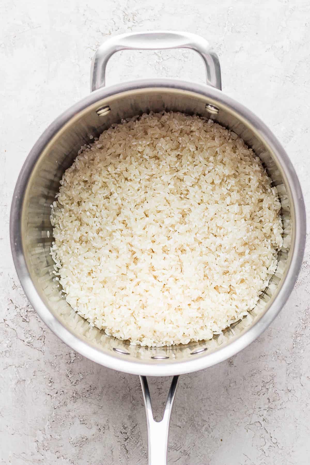 Rinsed sushi rice in a pot.