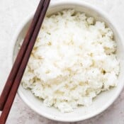 Bowl of Sushi Rice with chopsticks laying across.