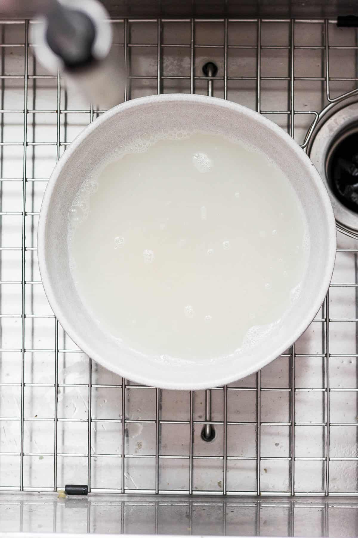 A bowl with sushi rice and water in it.