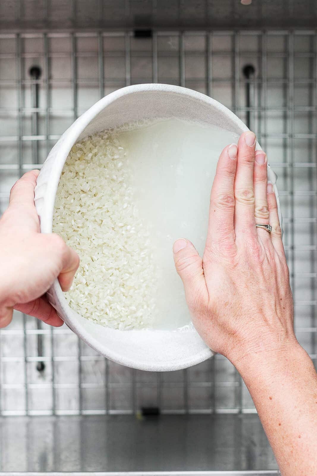 Water being drained out of the bowl with the rice staying in the bowl.