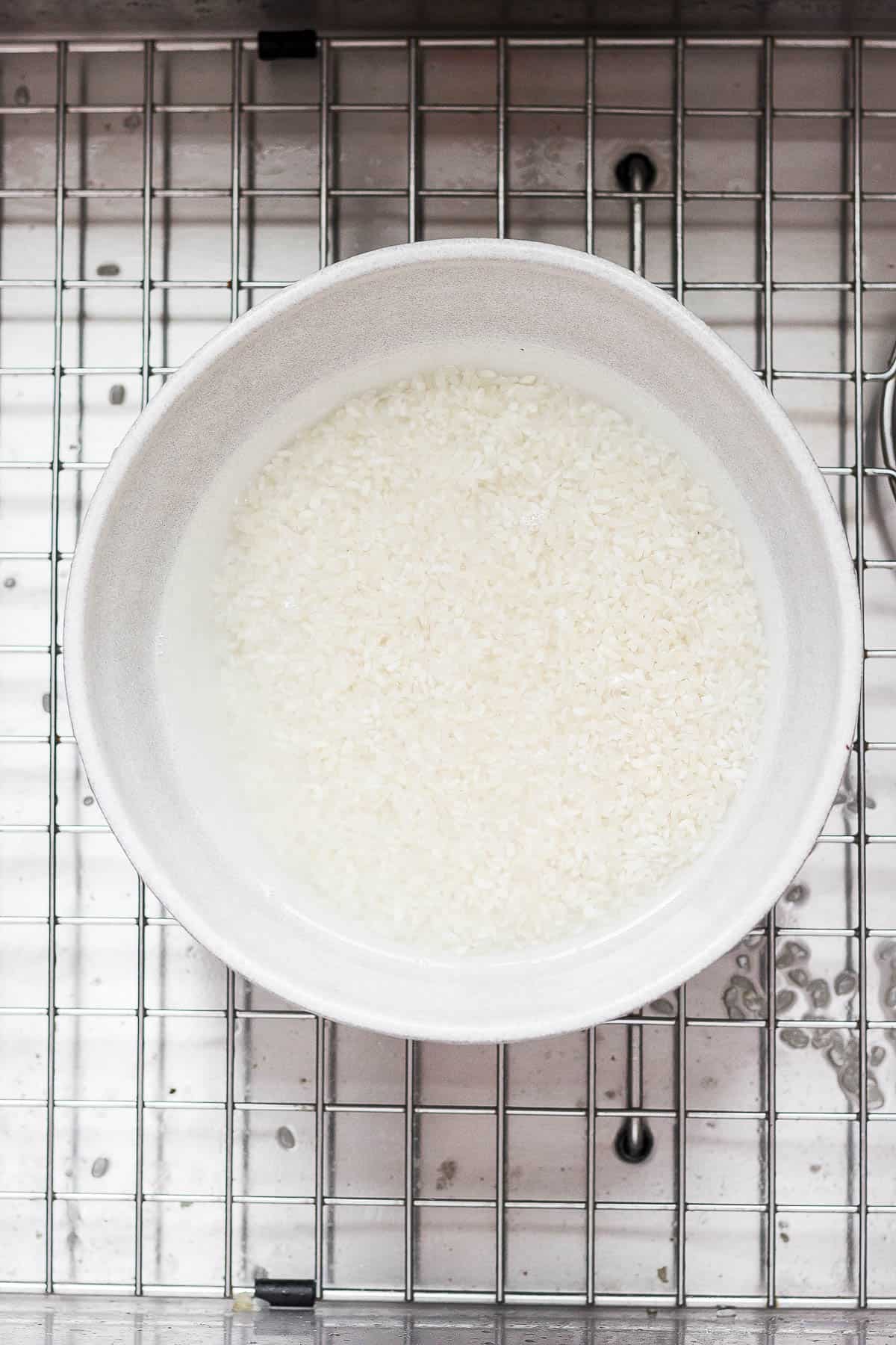 Rice in a bowl with clear water in it.