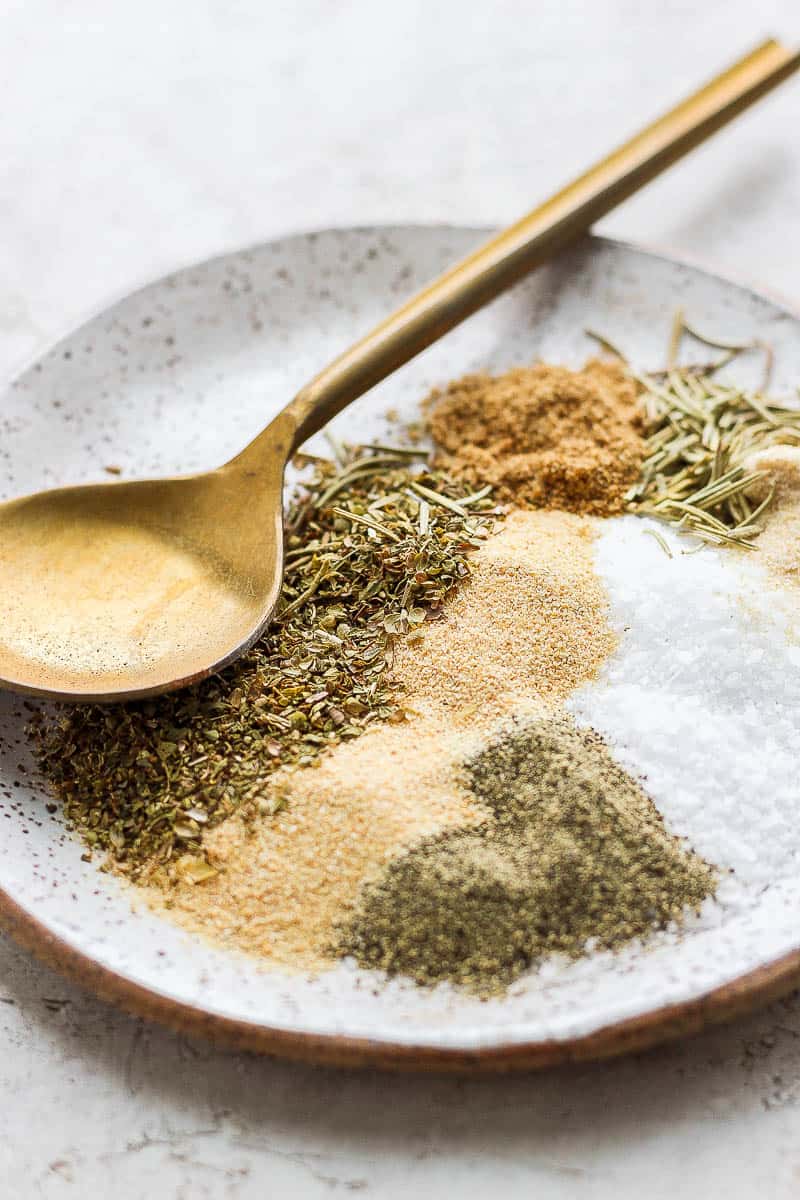 Ingredients for lamb seasoning on a plate with a spoon.