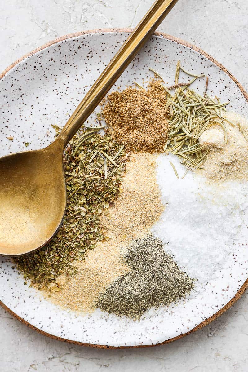 Ingredients for lamb seasoning on a plate with a spoon.