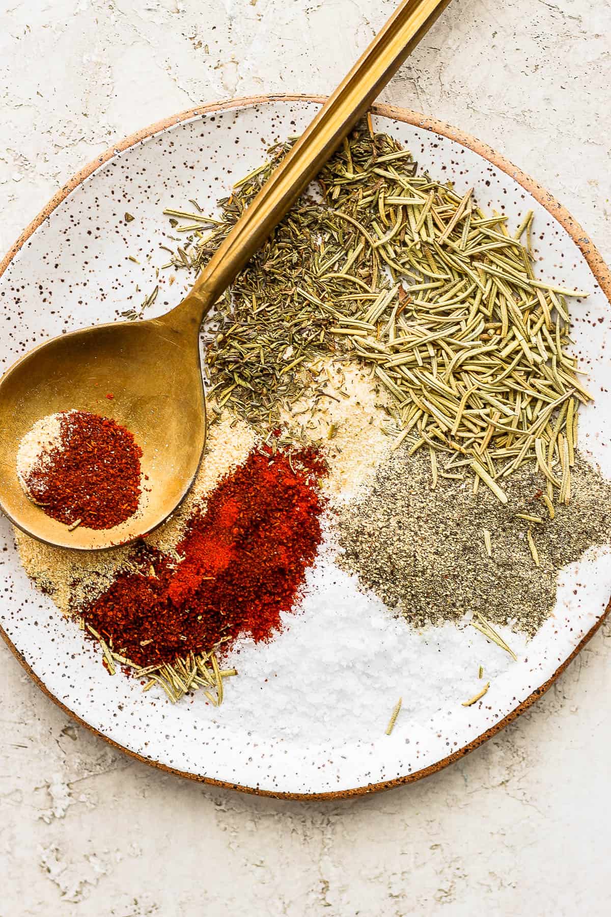 A plate of prime rib seasoning with golden spoon.