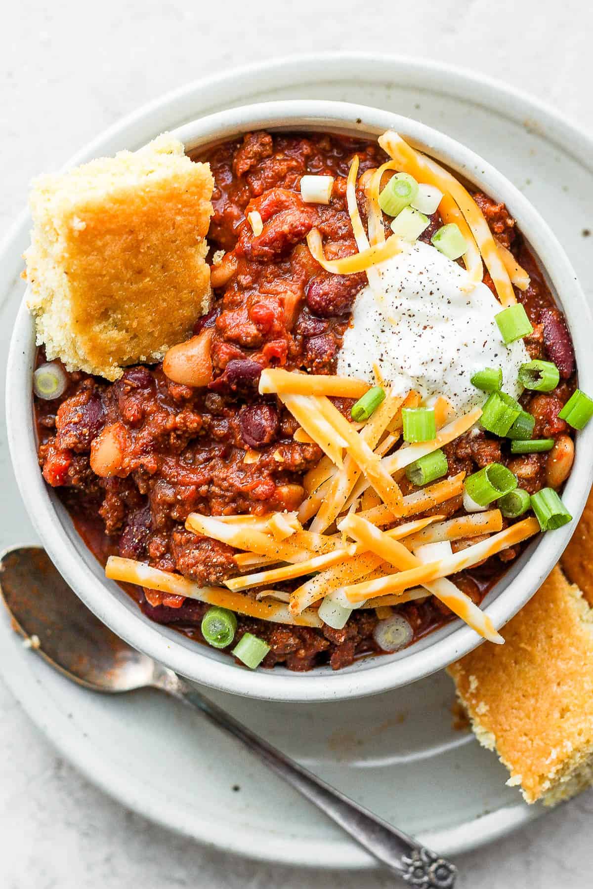 A bowl of slow cooker chili with toppings.