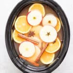 A slow cooker full of spiked apple cider.