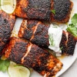 Plate of blackened salmon with dill sauce.