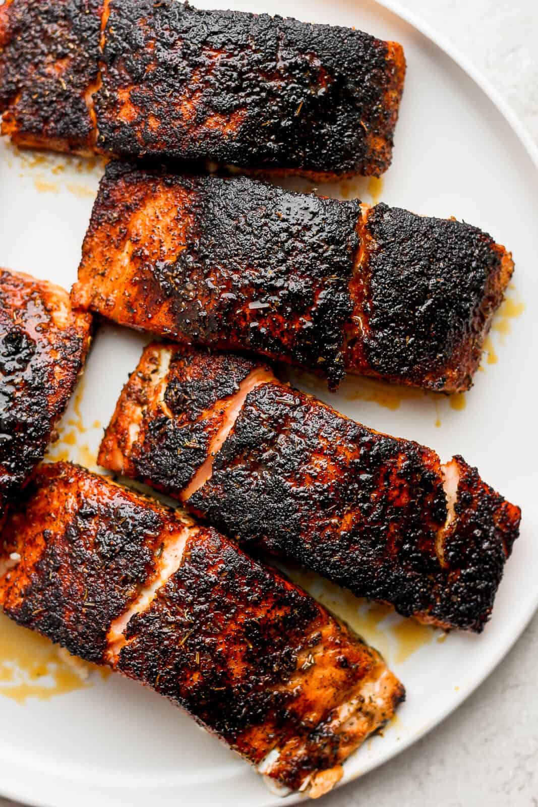 Blackened salmon fillets on a plate.