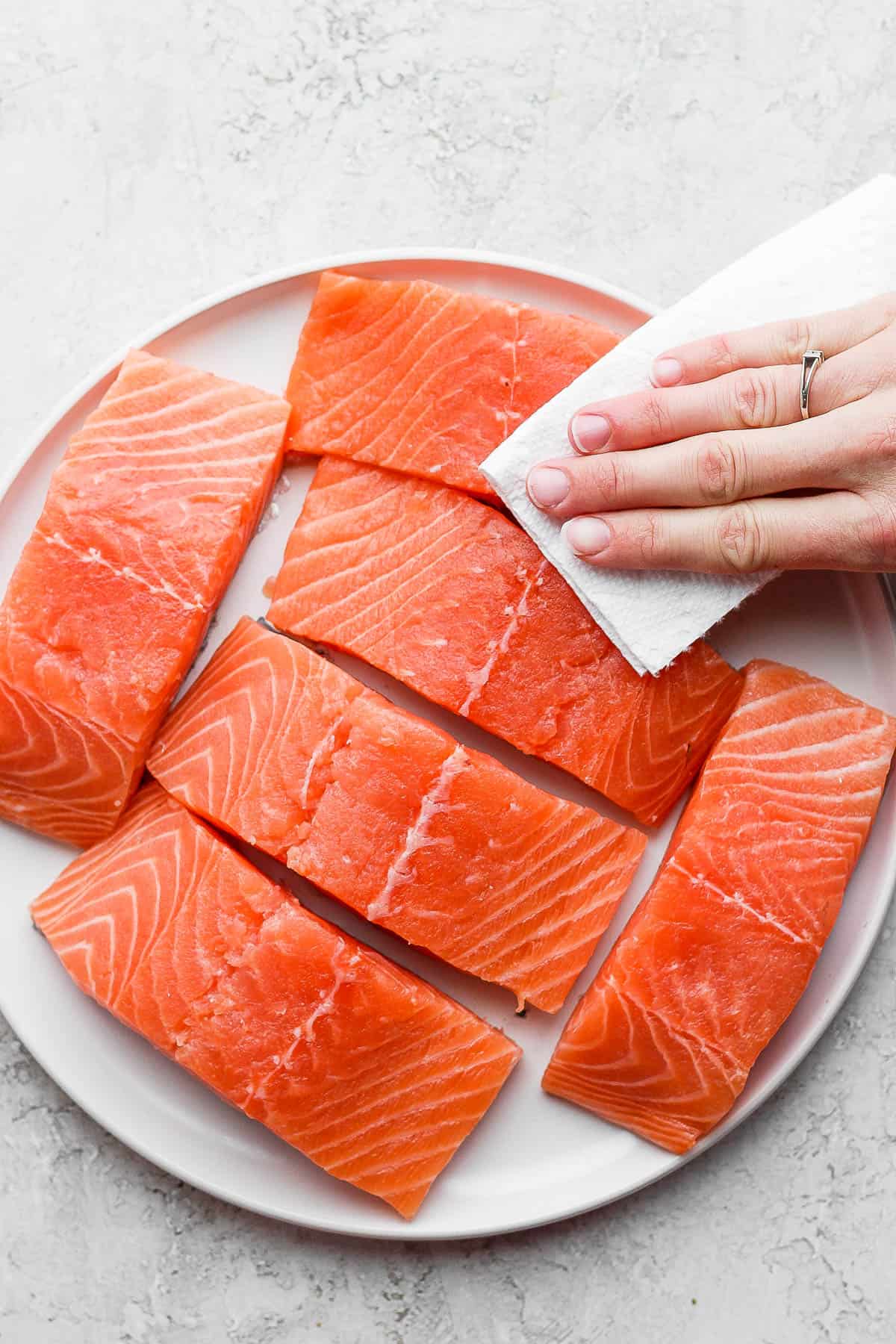 Salmon fillets being pat dry.