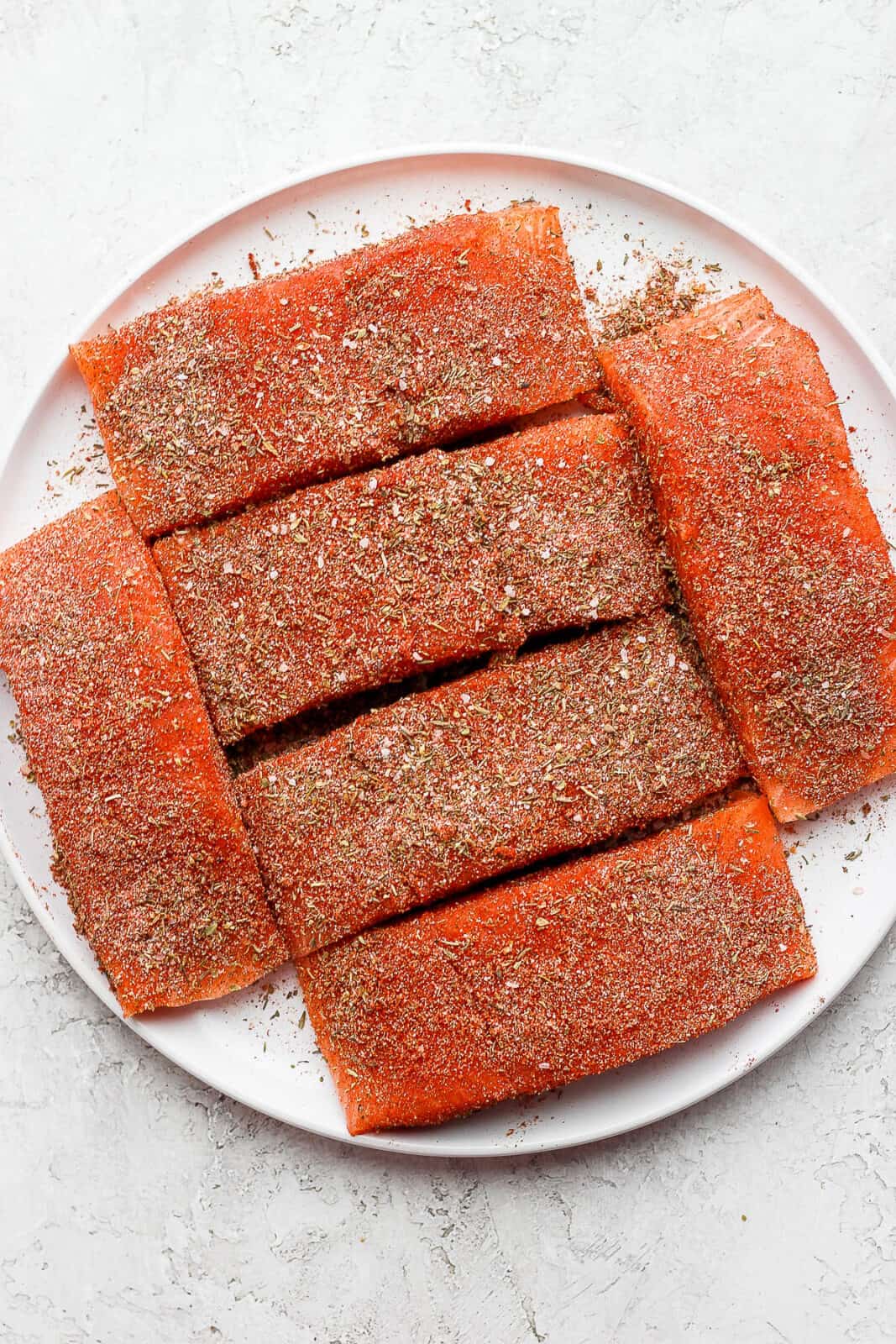 Plate of salmon covered in seasoning.