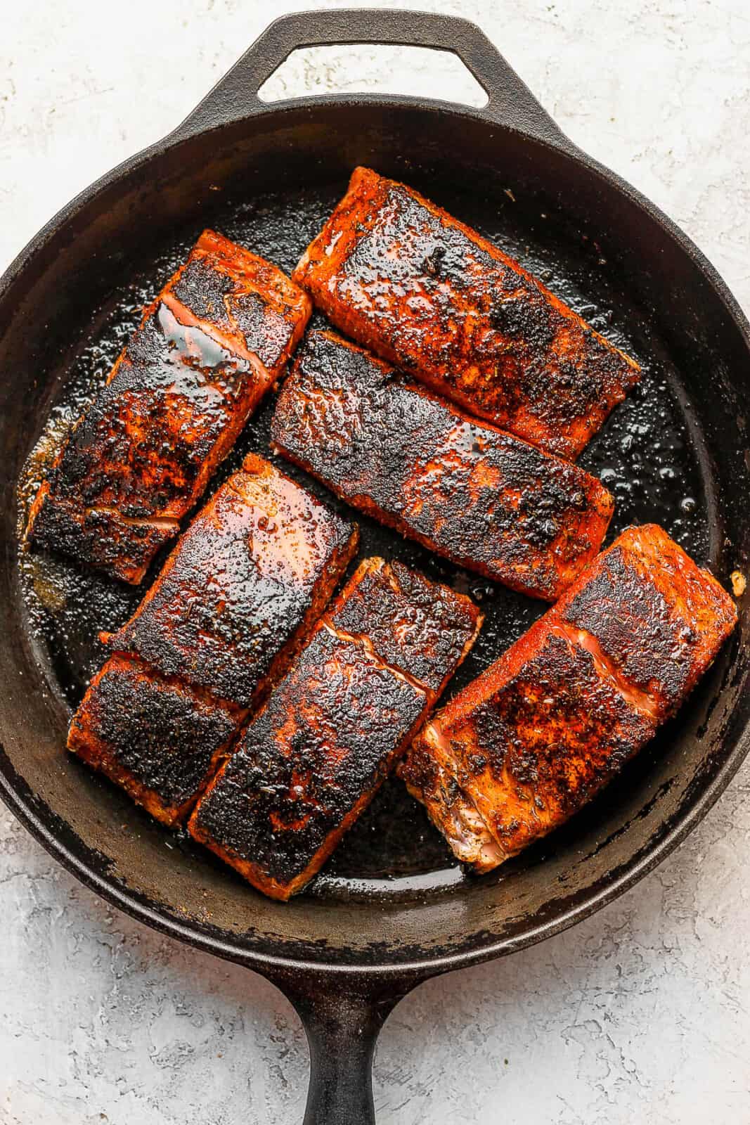 Blackened salmon in a cast iron skillet.