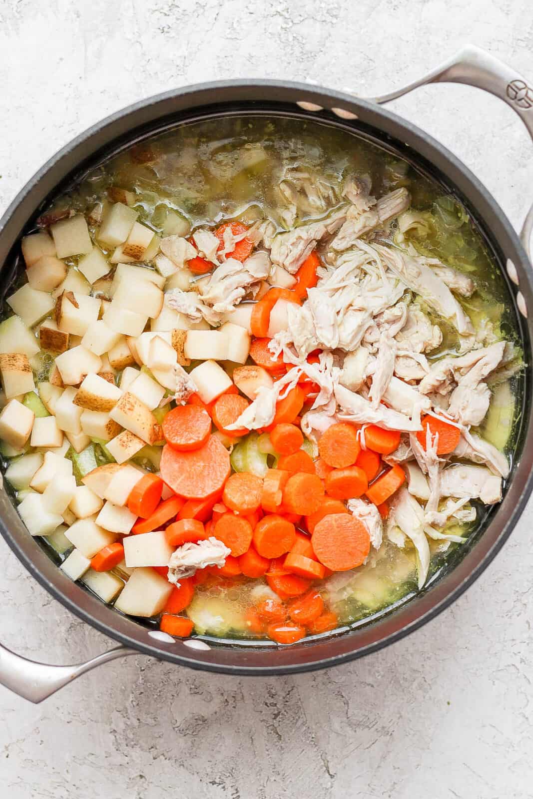 Shredded chicken added back to the pot along with the celery, carrots, and potato.