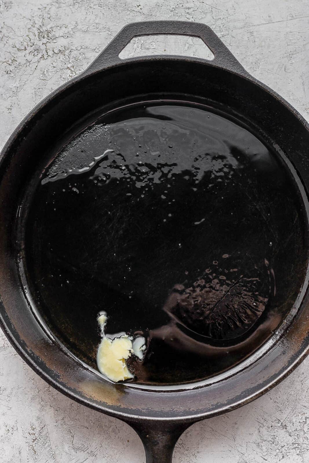Ghee melting in a cast iron skillet.