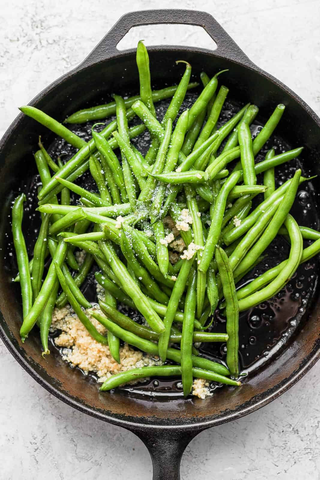 Green beans and salt added to the skillet.