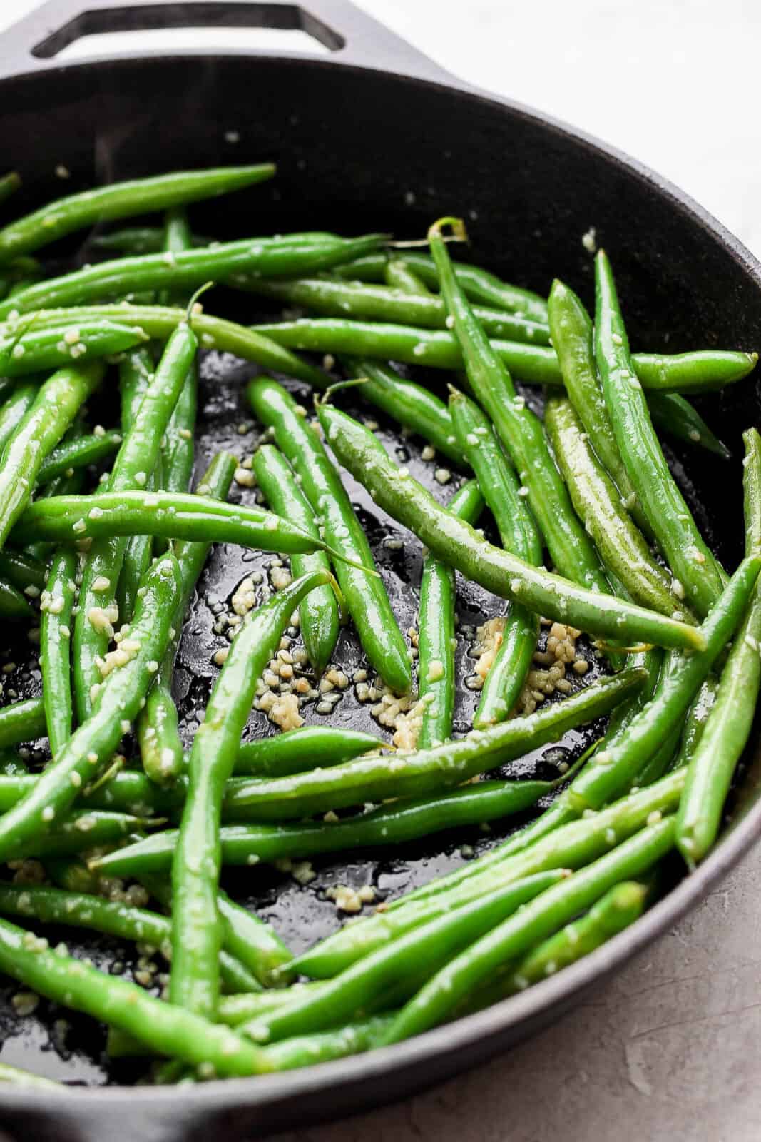 Garlic green beans in a cast iron skillet.