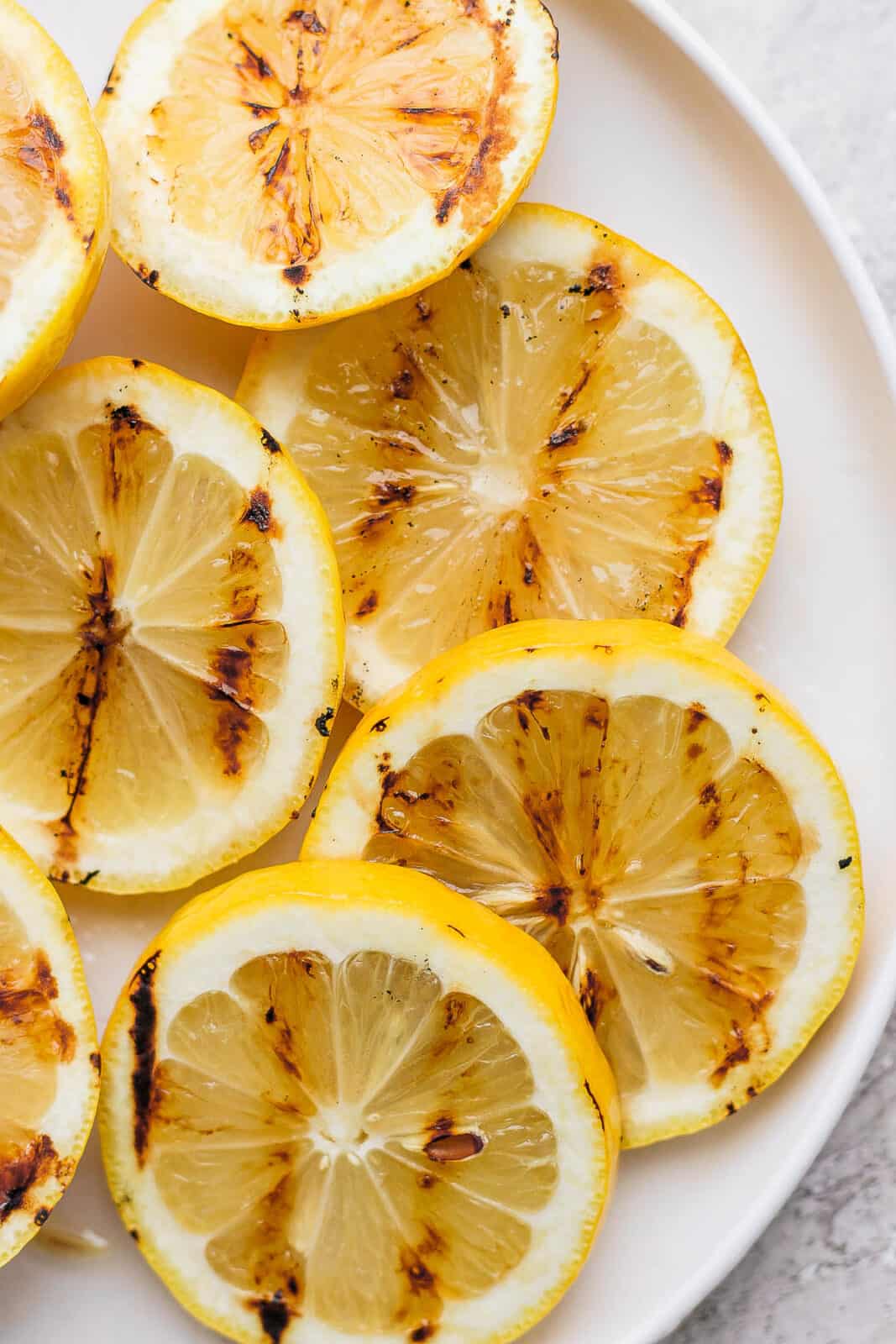 Grilled lemon slices on a plate.