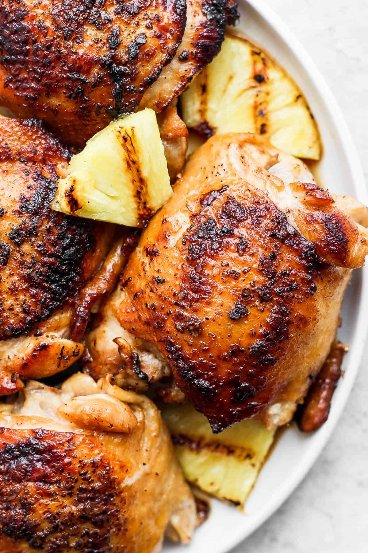 Plate of hawaiian chicken with grilled pineapple. 