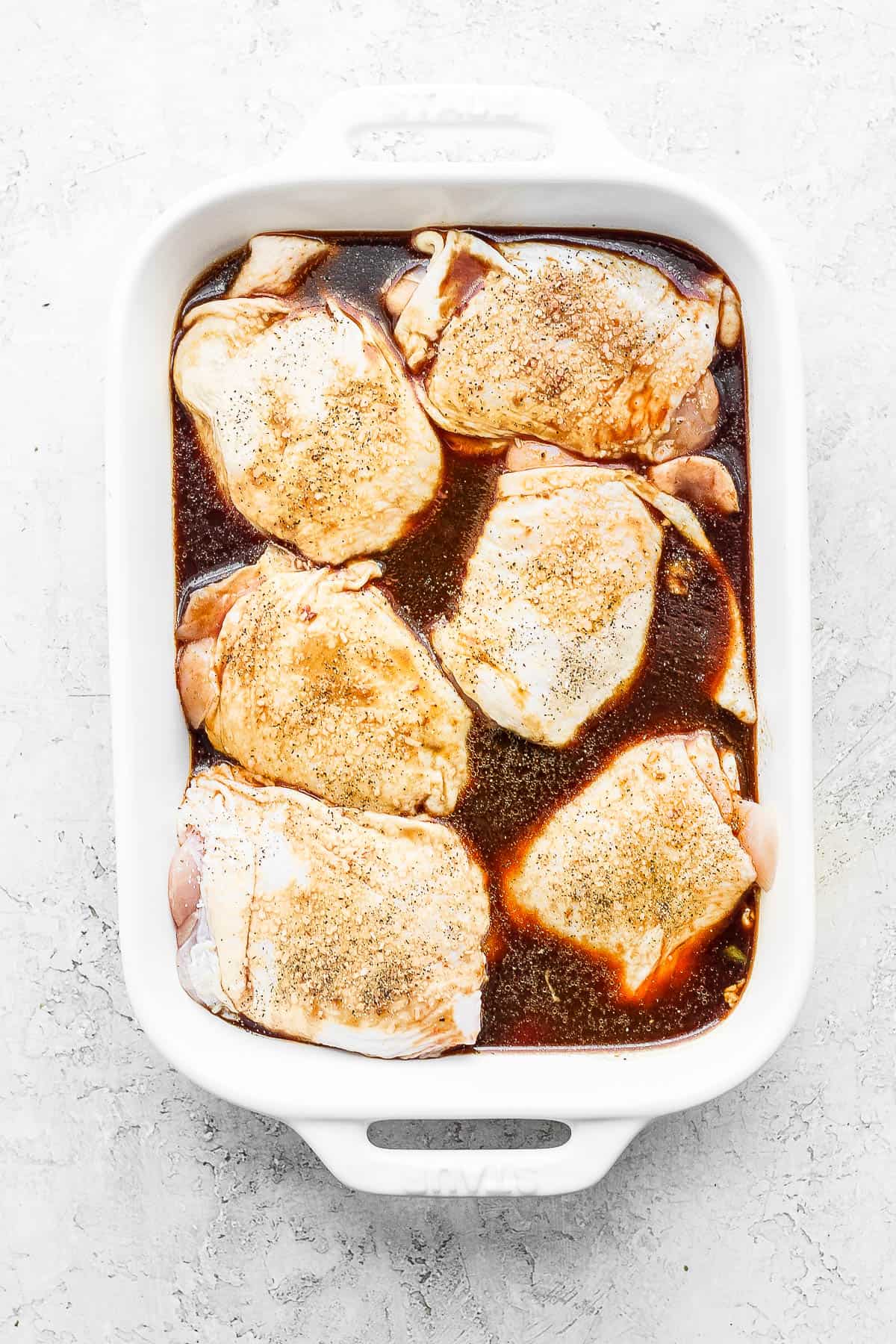 6 chicken thighs sitting in a marinade. 