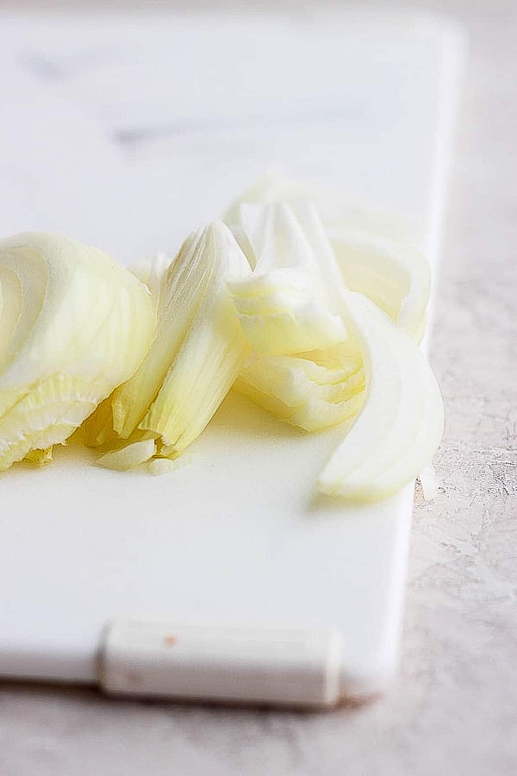 Onion slices on a cutting board.