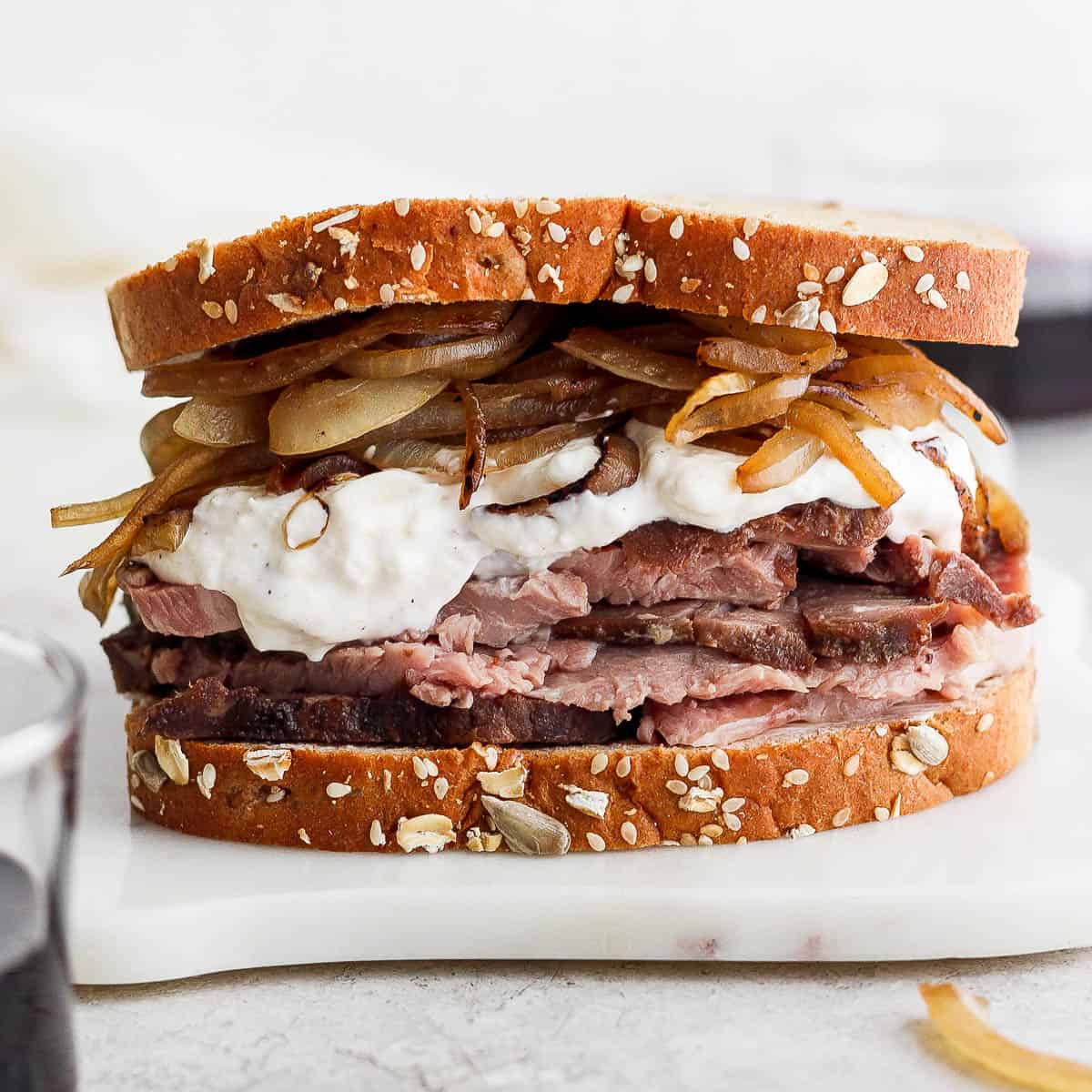 Leftover prime rib sandwich on a marble board.