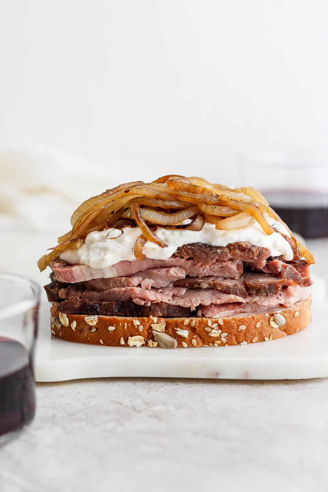 Prime rib, horseradish sauce, & caramelized onions stacked on a piece of bread.