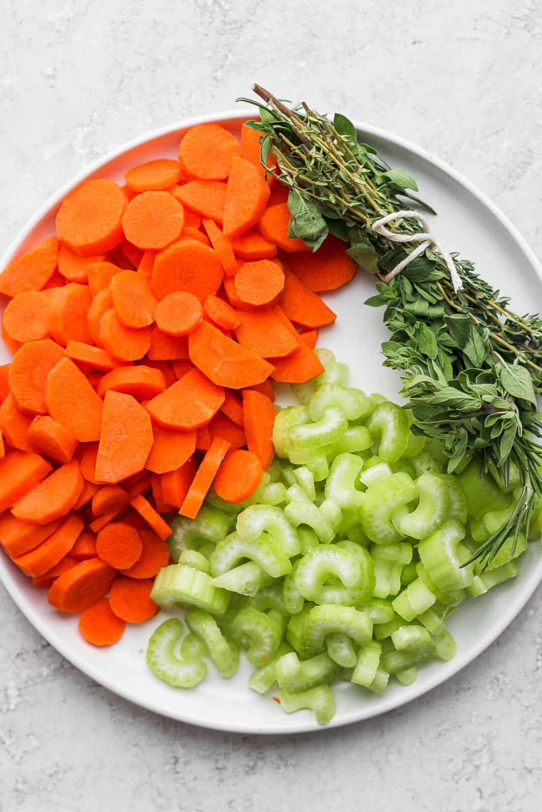 An herb bundle with cut-up carrots and celery.