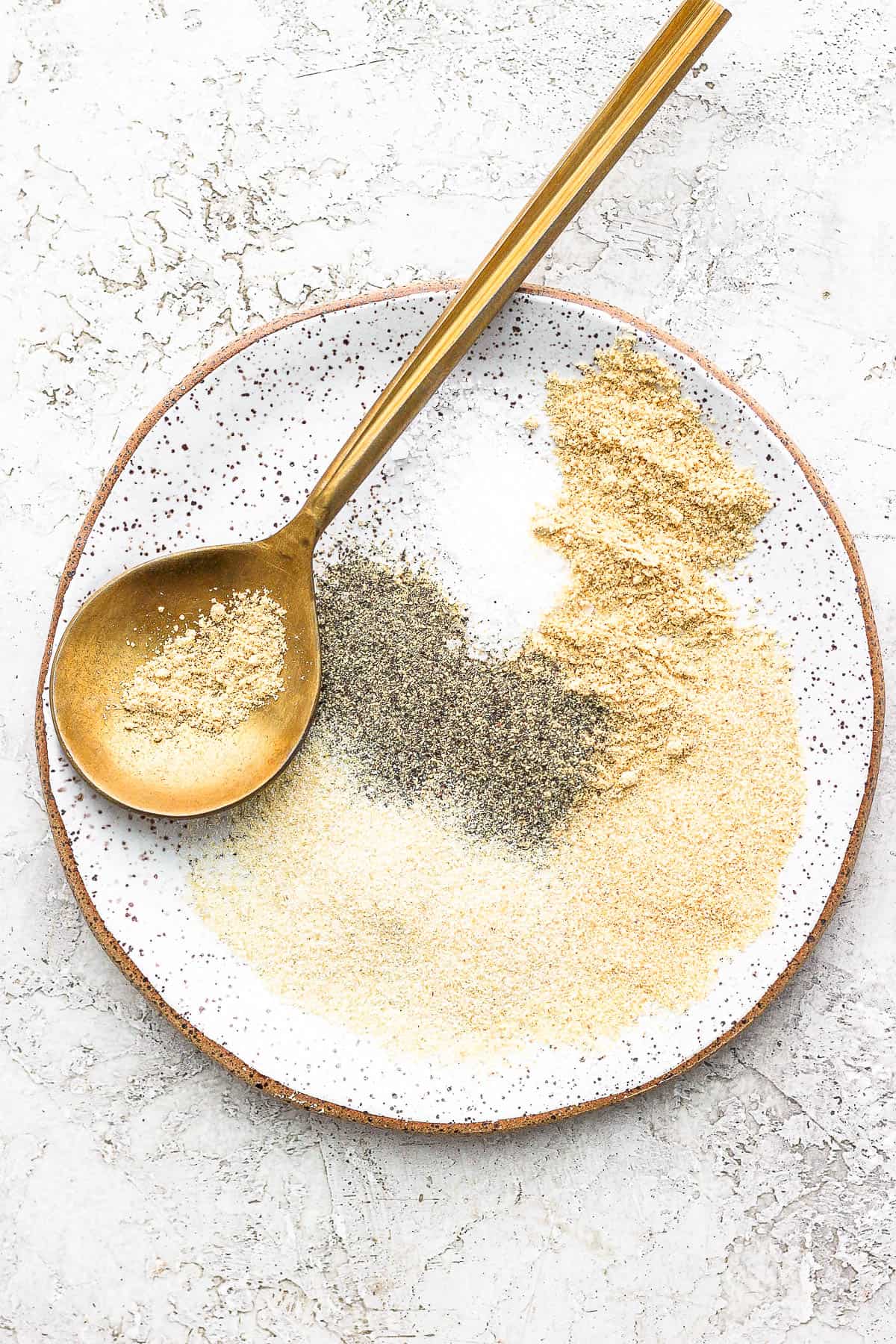 Plate of meatloaf seasoning with golden spoon.