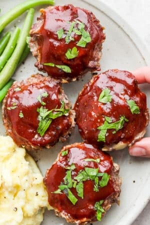 Plate of mini meatloaf muffins, green beans and mashed potatoes.
