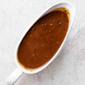 A gravy boat filled with pork gravy.
