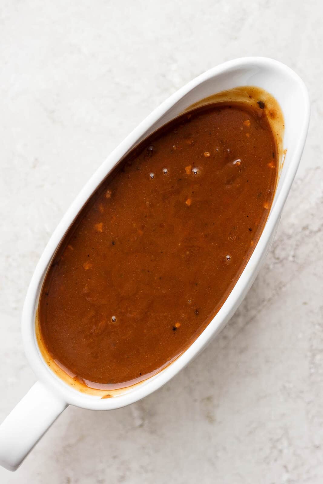 A gravy boat with homemade pork gravy in it. 