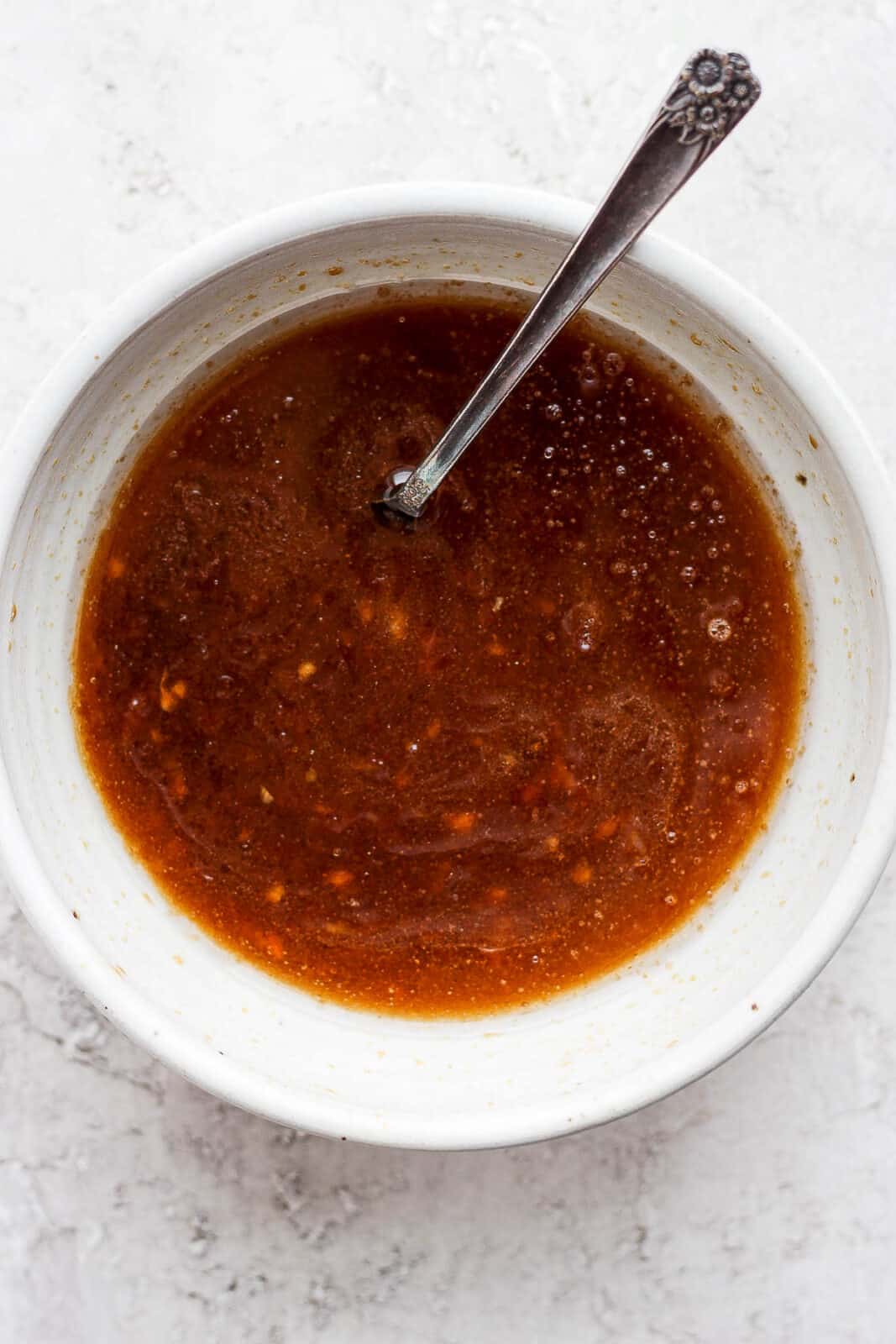 Pork roast marinade in a bowl with a spoon.