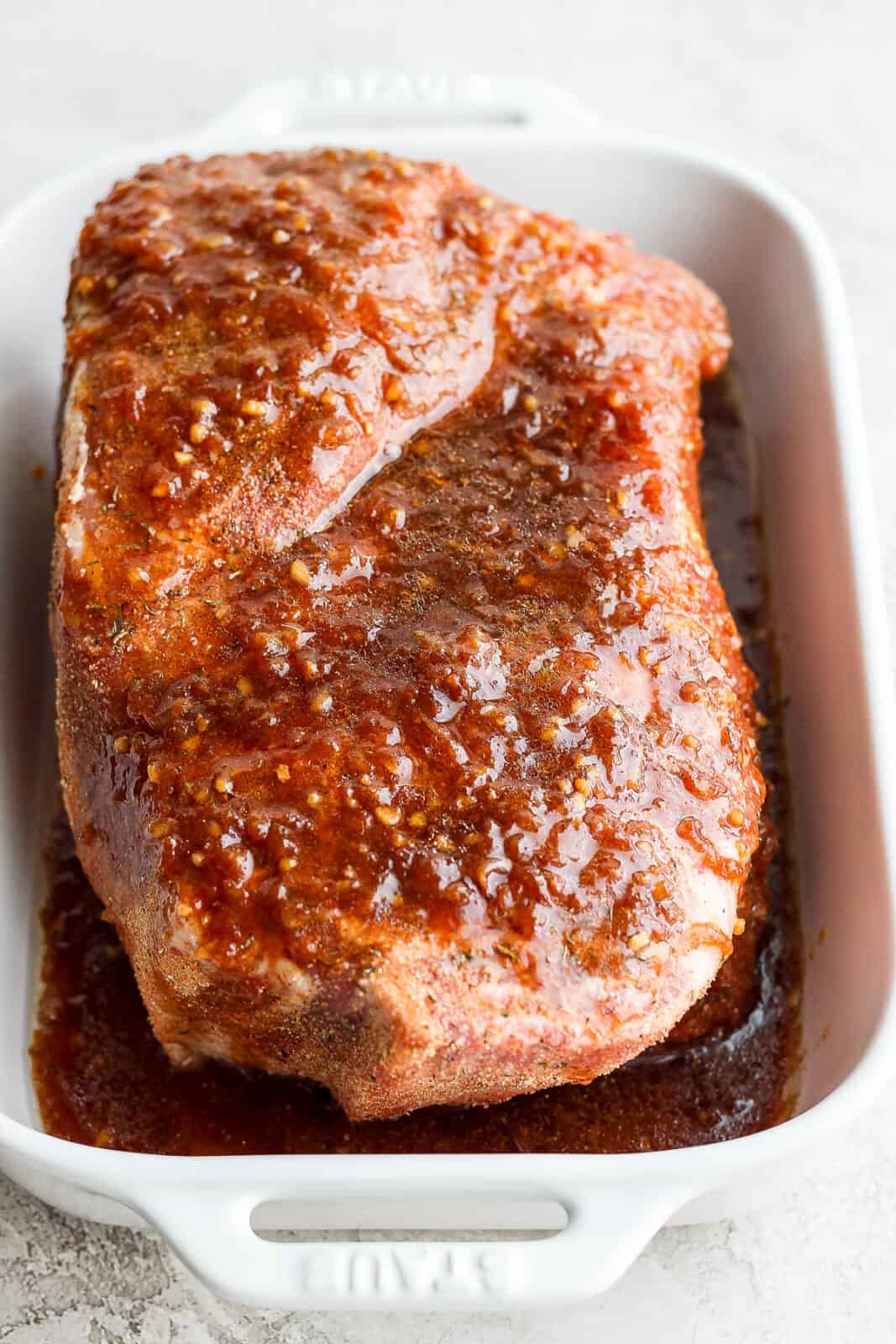 Marinade over a pork roast in a shallow dish.