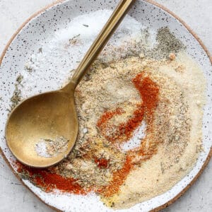 Plate of pork roast seasoning with golden spoon.