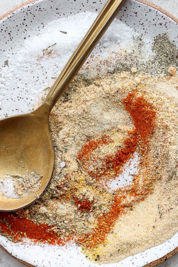 Plate of pork roast seasoning with golden spoon.