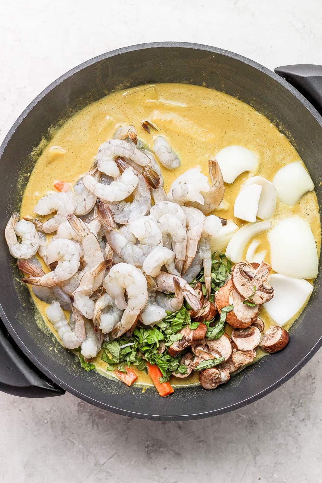 Shrimp, basil, mushrooms and onion added to the wok.