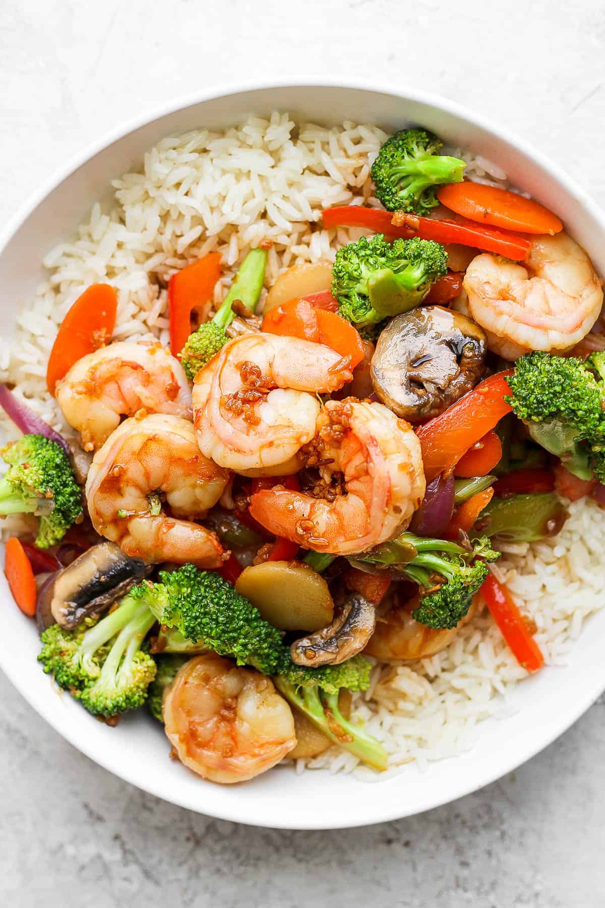 A bowl of shrimp stir fry on rice.