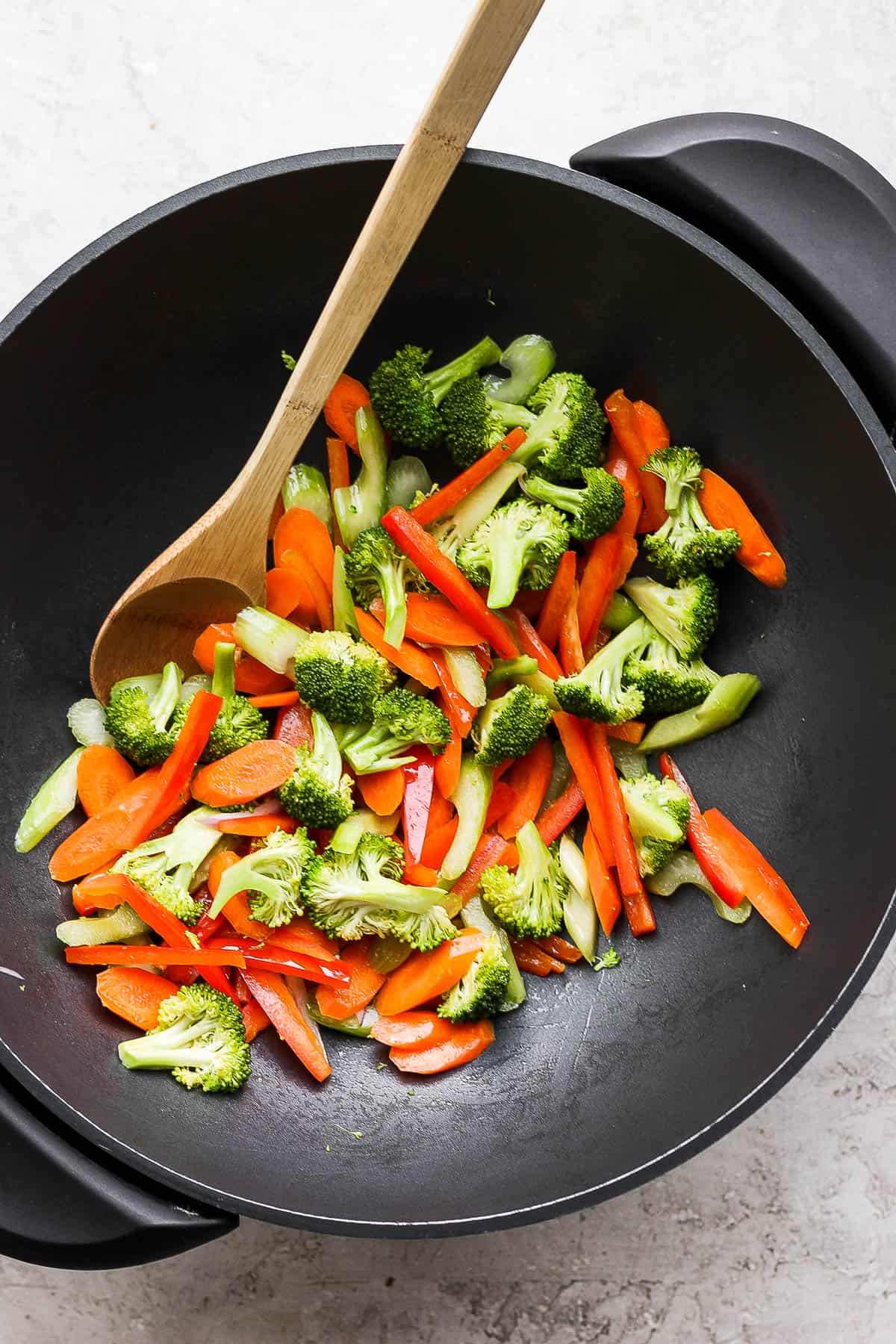 Carrots, bell pepper, celery, and broccoli in a wok.