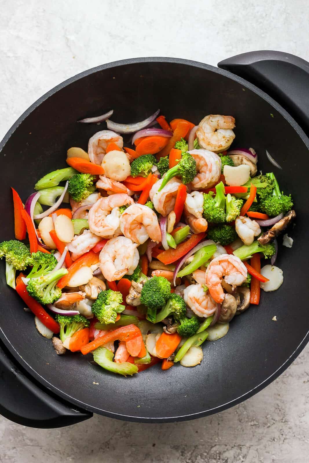 The shrimp stir fry in the wok before adding the sauce.
