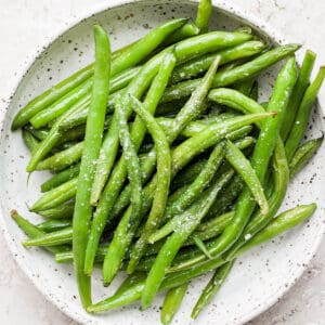 Smoked green beans in a shallow dish with some salt sprinkled on top.