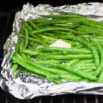Smoked green beans in a foil basket on a smoker.