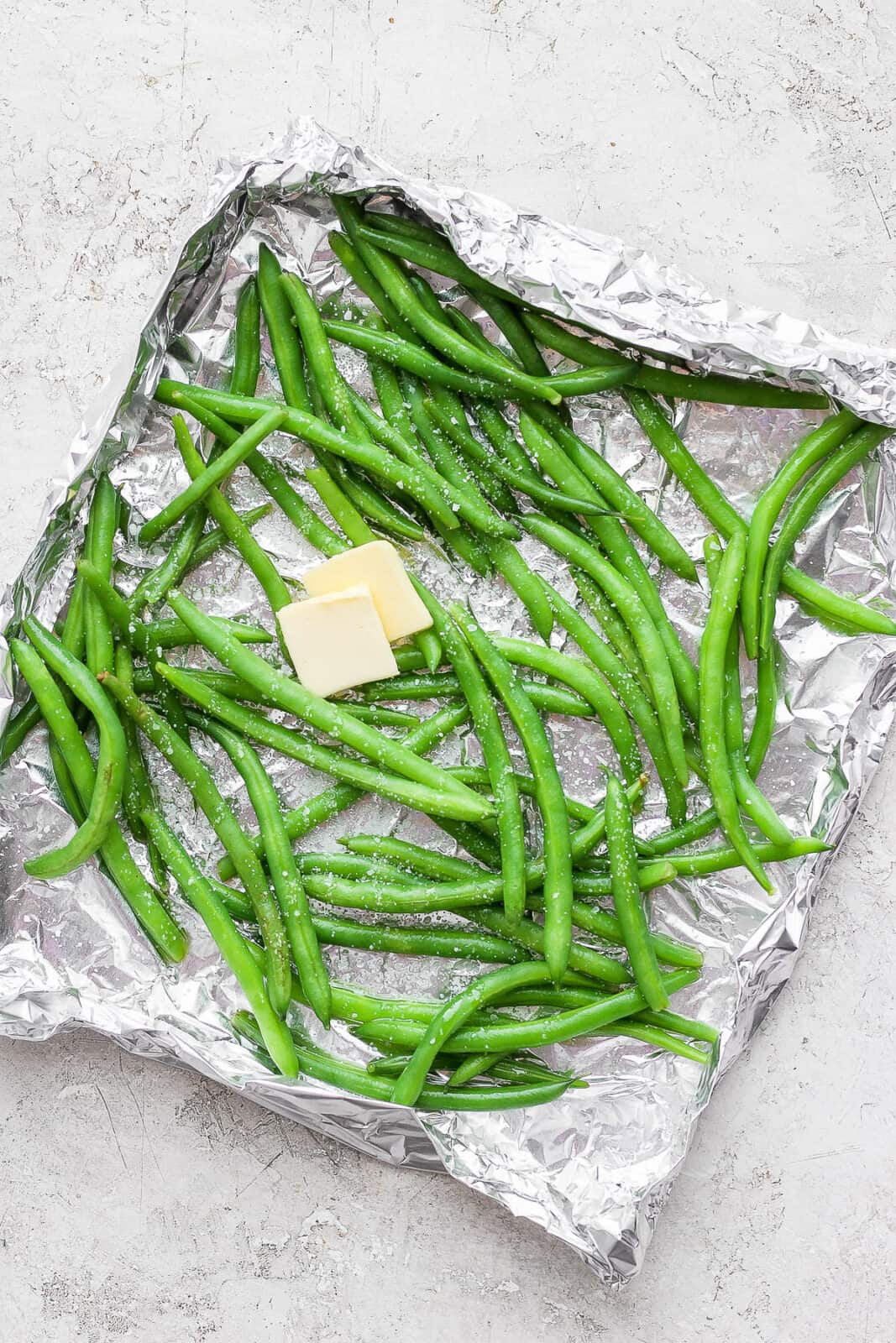 Green bean in foil basket with oil, salt and butter.