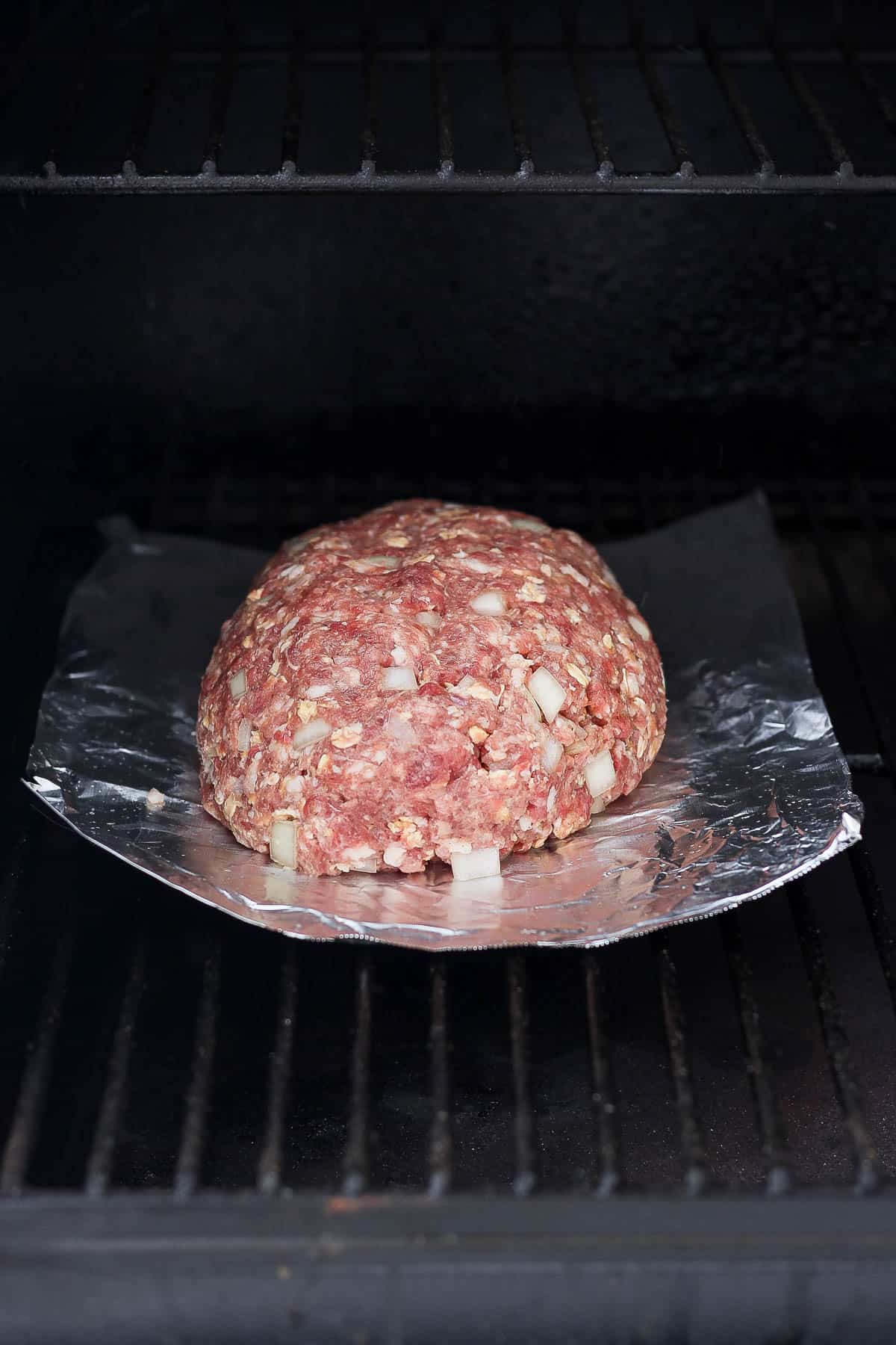 Formed meatloaf on a piece of foil on the smoker.