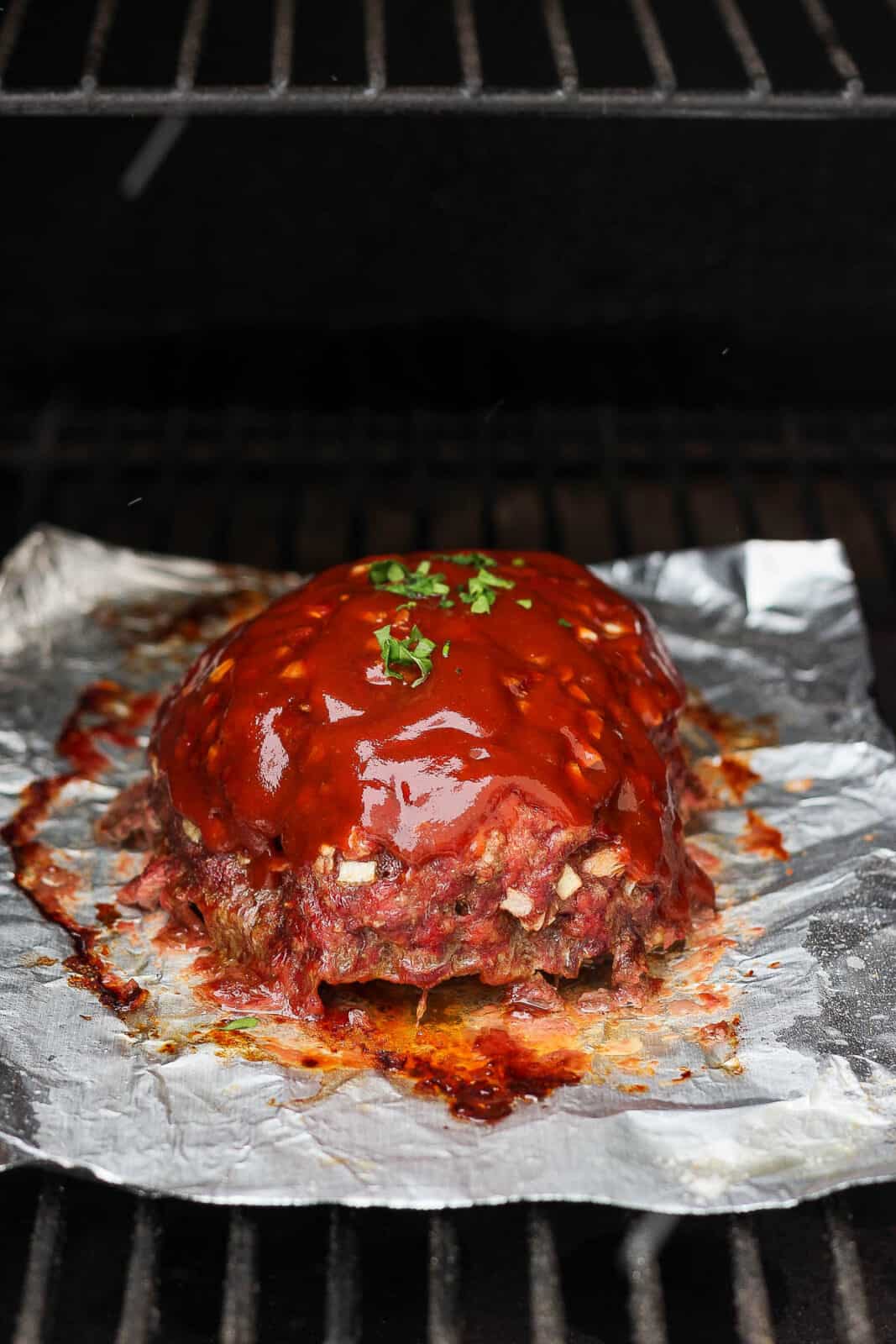 Smoked meatloaf on a smoker with glaze.