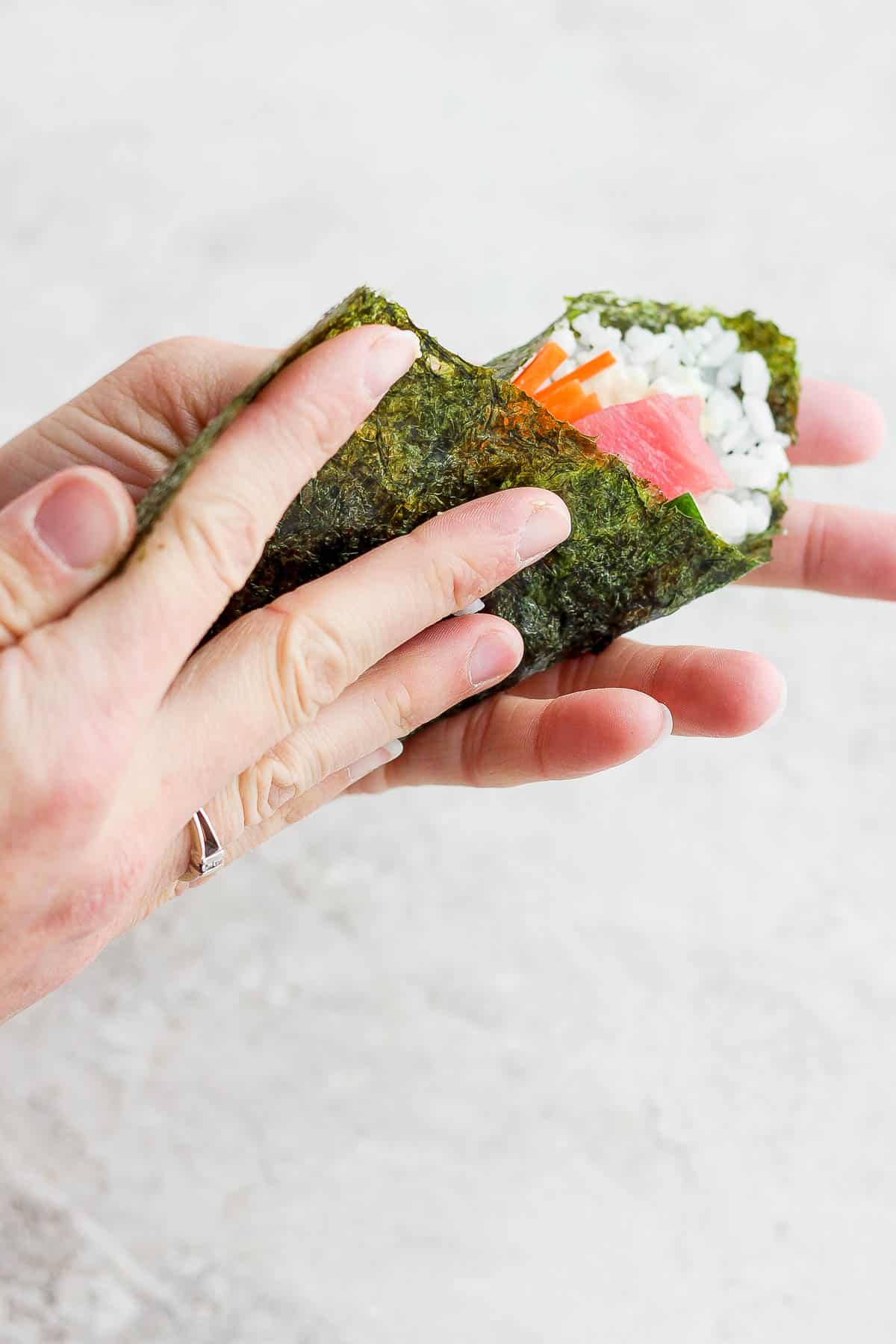 The other end of the nori sheet being pulled across making a cone shape and therefore a sushi hand roll.