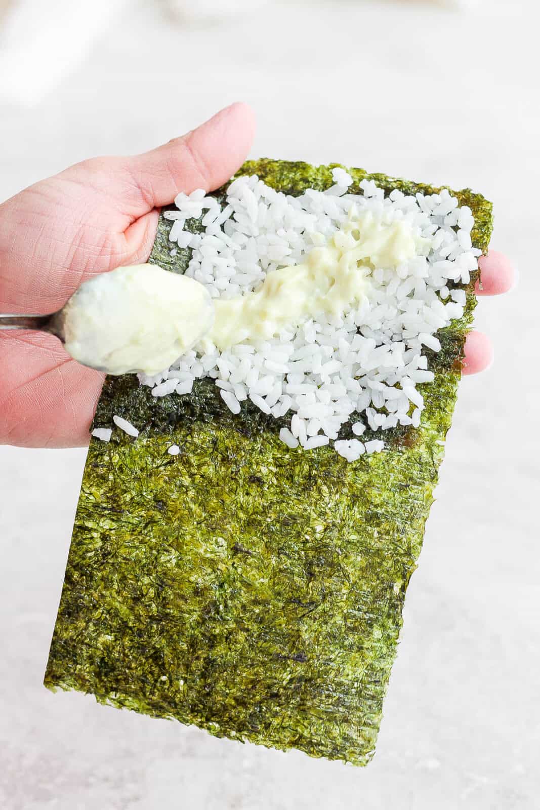 Wasabi mayo being spread on the sushi rice.