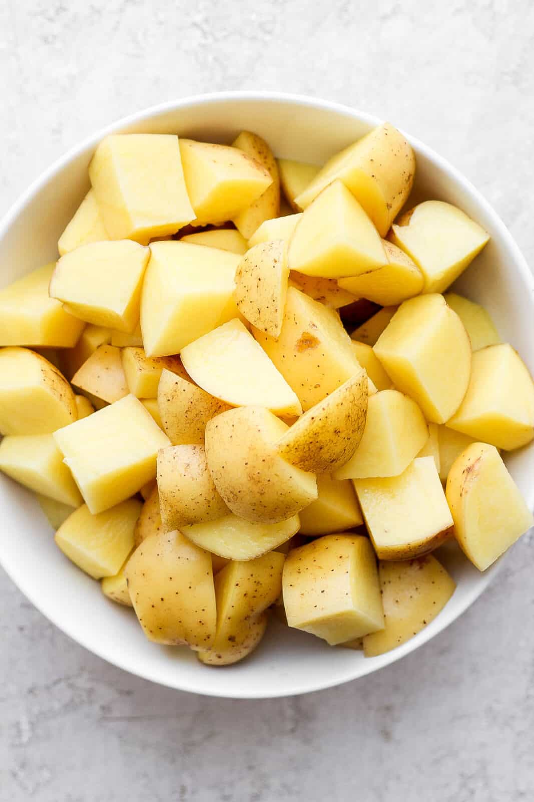 Bowl of cut-up yukon gold potatoes.
