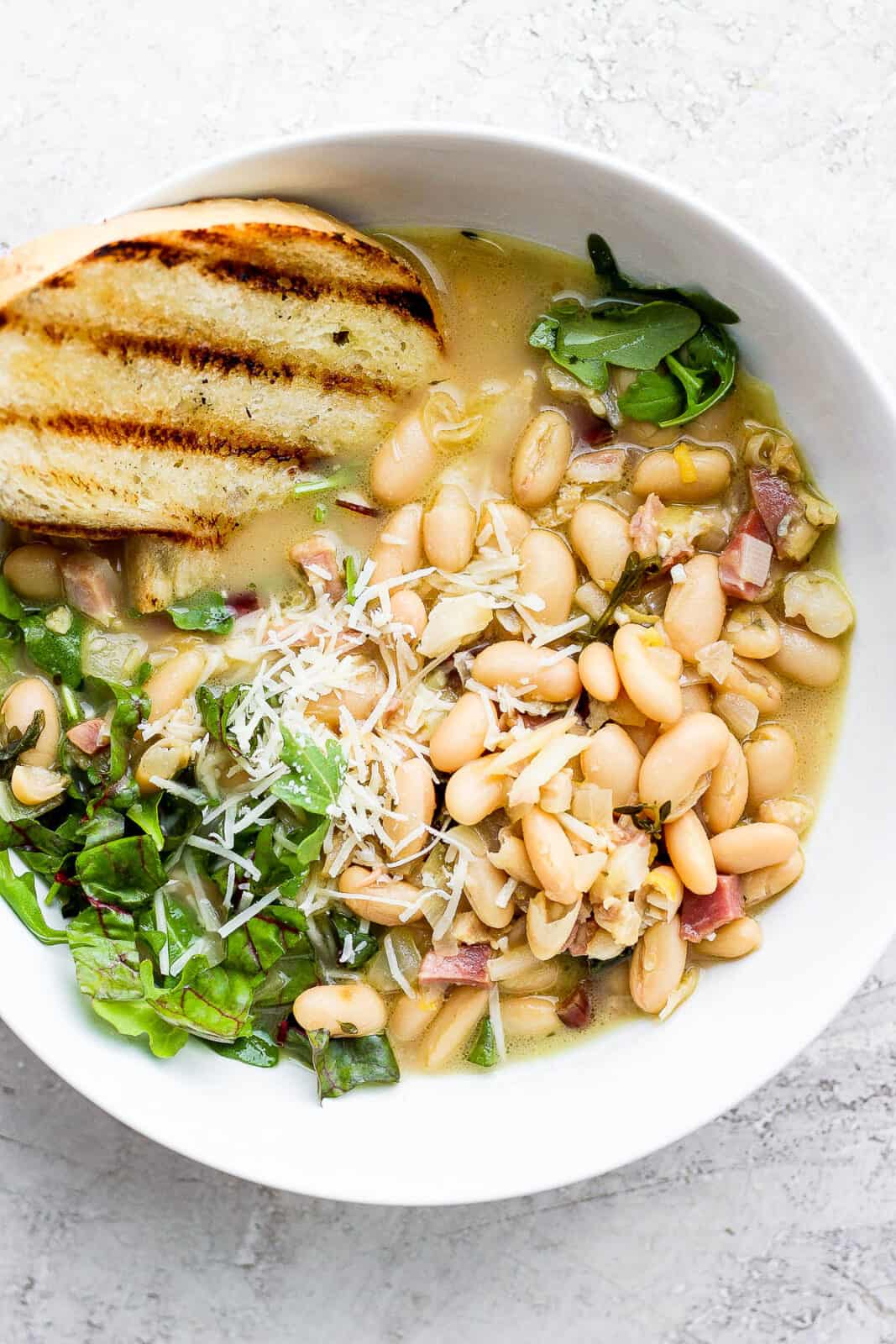 A bowl of brothy beans with grilled bread.