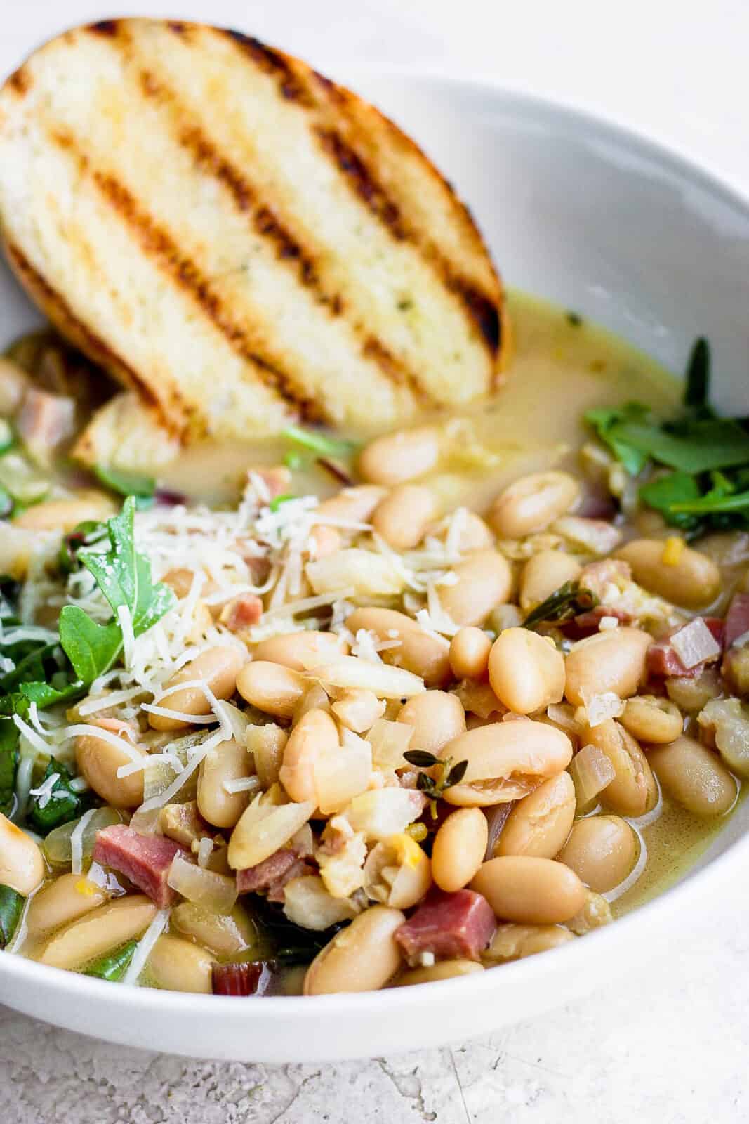 A bowl of brothy beans with grilled bread.